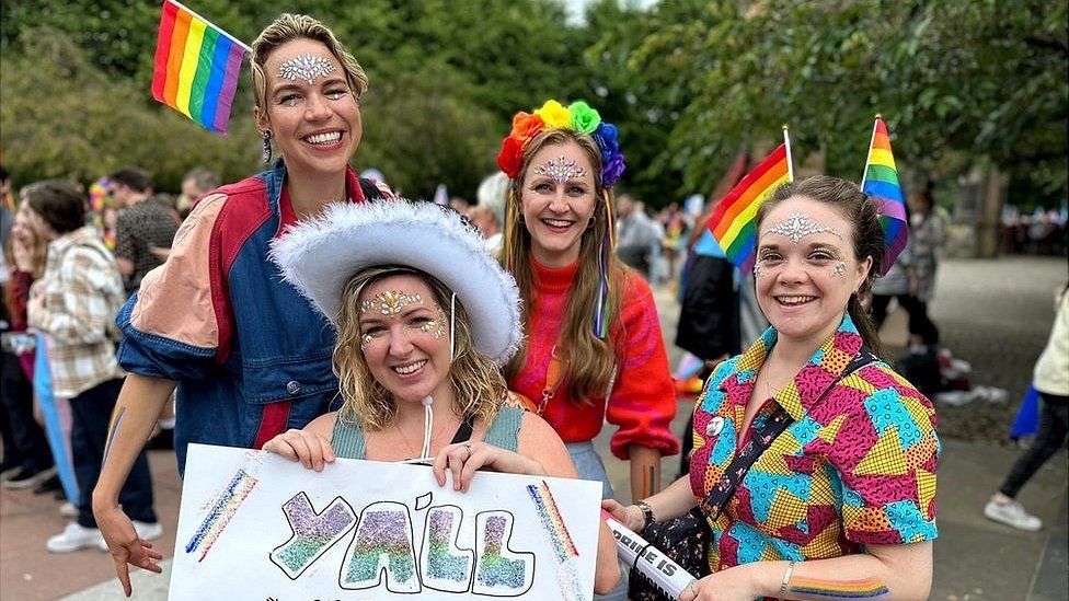 Women in rainbow cowboy outfits