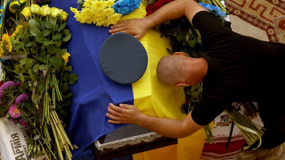 A Ukrainian soldier pays his respects to Andrii Pilshchykov.. Photo: 29 August 2023
