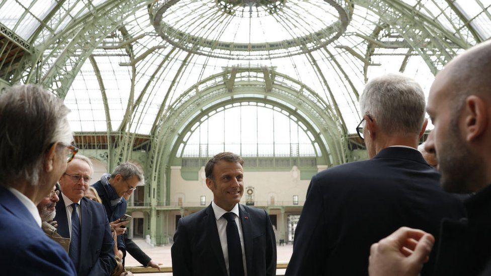 France's President Emmanuel Macron (C) speaks during a visit in Le Grand Palais, in Paris, on April 15, 2024, 100 days ahead of the Paris 2024 Olympic Games.