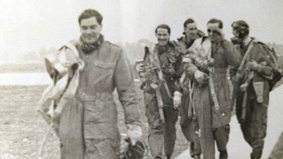 Squadron Leader RJ Morgan is pictured in the background with sunglasses