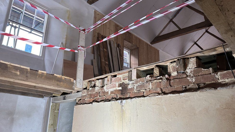 Inside of an old building showing two exposed stories and scaffolding