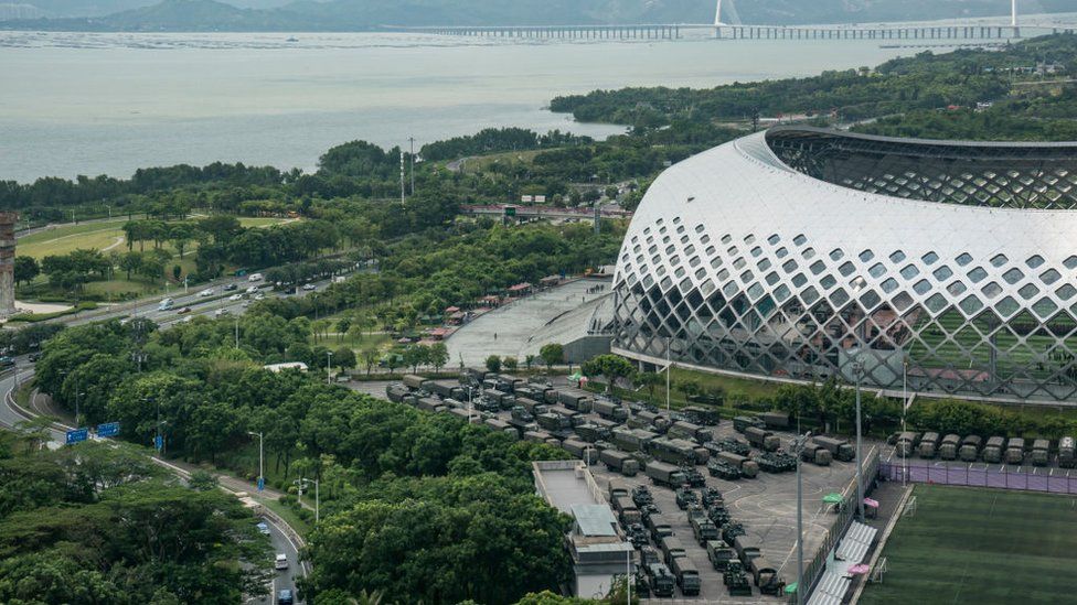 Trucks and armoured personnel vehicles park outside the Shenzhen Bay stadium on August 16, 2019 in Shenzhen