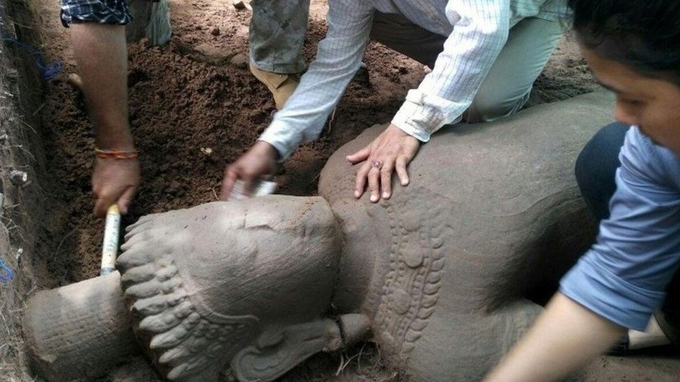 Archaeologists excavating the sandstone statue at the Angkor Wat temple complex in Siem Reap province (01 August 2017)