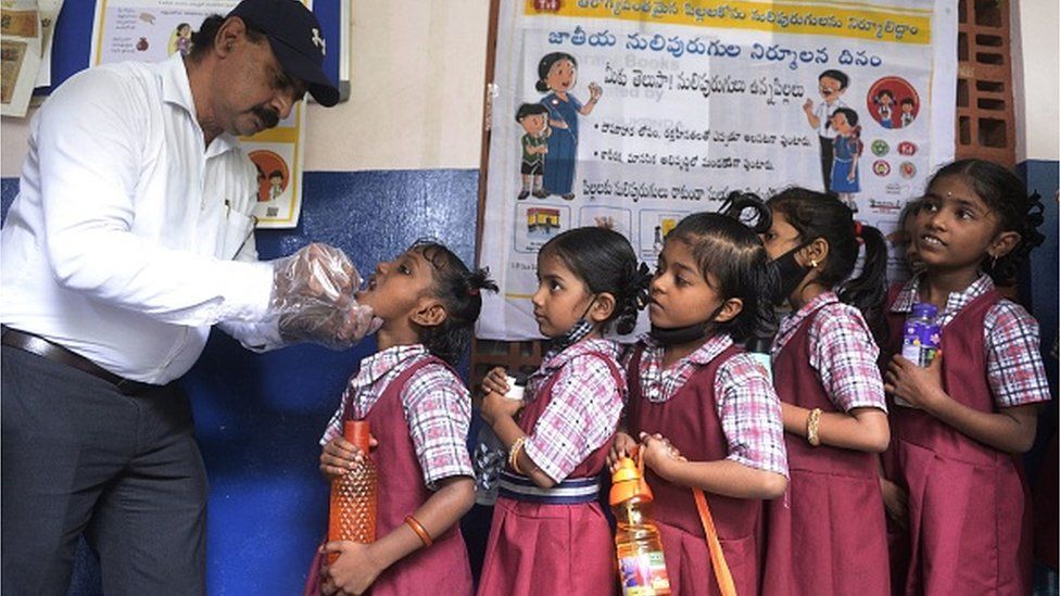 Учитель дает детям таблетку от гельминтов для предотвращения кишечных глистов в рамках Национальной программы Индии по дегельминтизации в государственной начальной школе в Хайдарабаде, 15 сентября 2022 г.