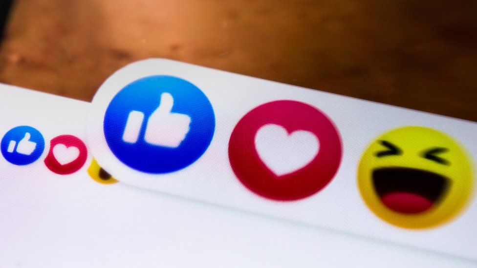 Close-up shot showing the Facebook reaction buttons like, love and laugh on a mobile screen