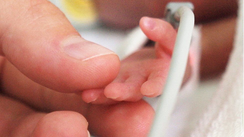 Mother holding her baby's hand