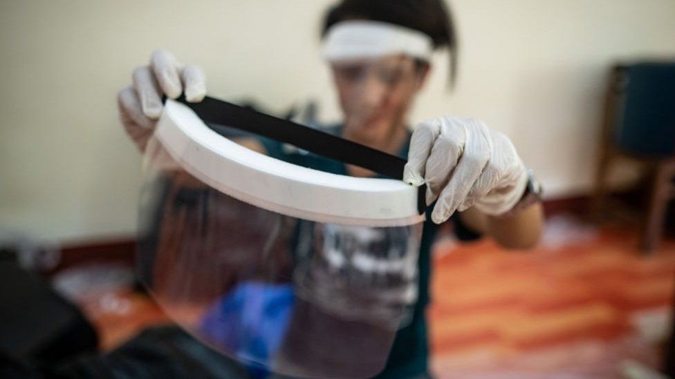 A medical student checks a handmade face shield before delivering them to doctors and nurses in Yangon, Myanmar.