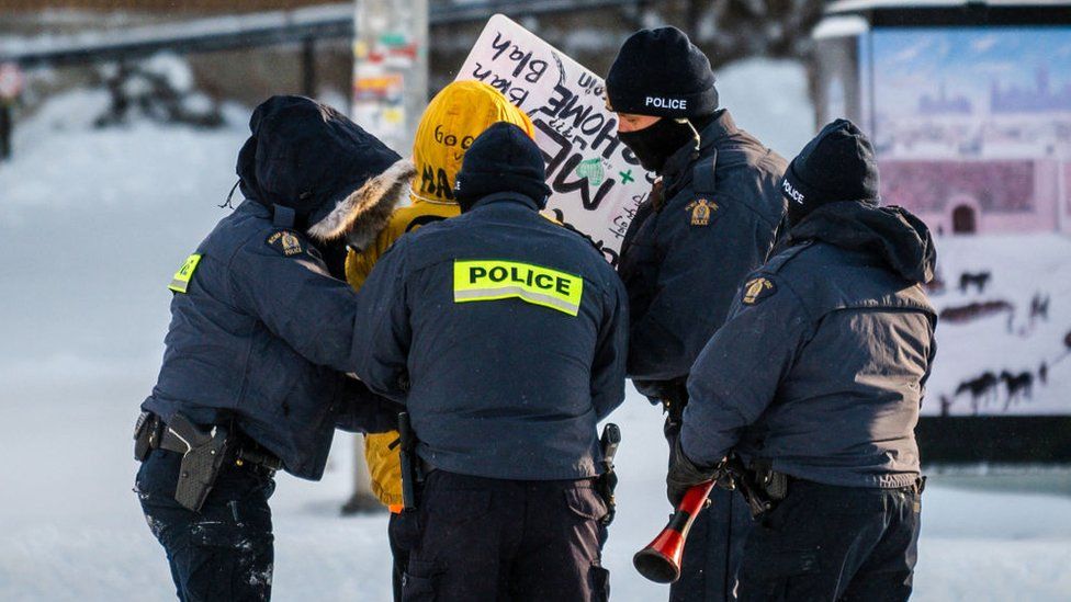 Демонстрант арестован полицией в Оттаве 18 февраля 2022 года, когда они начинают разгонять протестующих, требующих отмены мандатов Covid-19.
