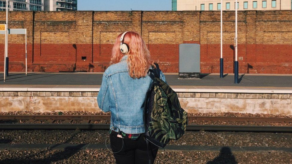 A woman waits at a train platform