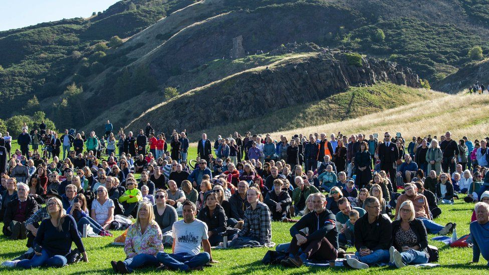 Members of the public watch the State Funeral of Queen Elizabeth II on a big screen in Holyrood Park, Edinburgh