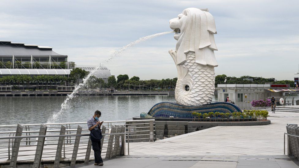 A lone man by the Merlion statue in Singapore
