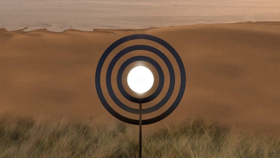 Three large concentric circles overlooking a beach with the pond shining white in the middle