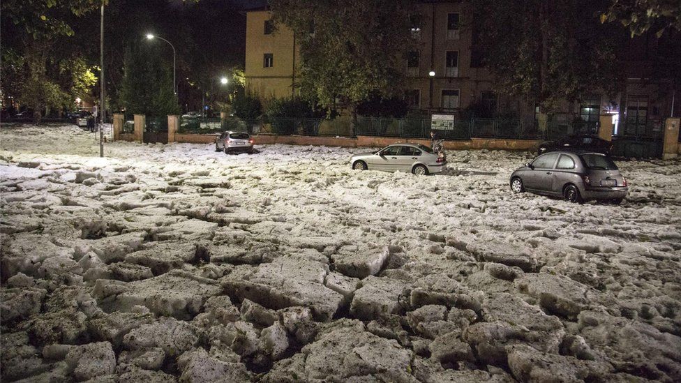 Cars are locked in a road covered with hail in Rome