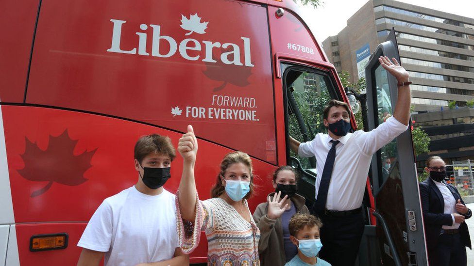 Премьер-министр Канады Джастин Трюдо, его жена Софи Грегуар Трюдо и их дети Ксавье, Элла-Грейс и Адриен машут сторонникам, садясь в автобус своей кампании 15 августа 2021 года в Оттаве, Канада