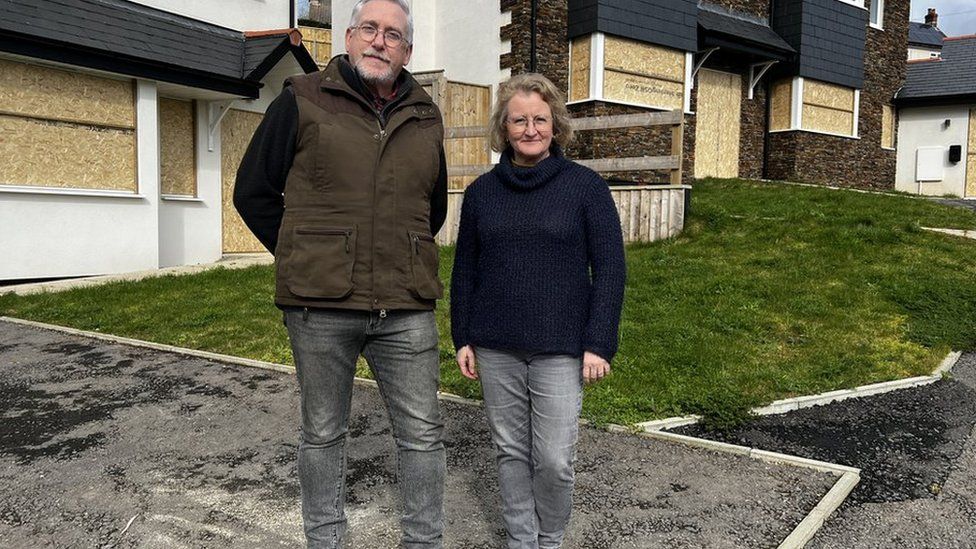 Michael and Adele stood outside the houses that have been built