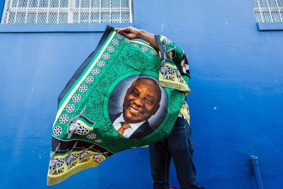A street vendor sells regalia depicting South African President Cyril Ramaphosa outside the venue for the African National Congress (ANC) 107th anniversary celebrations at the Moses Mabhida Stadium in Durban on January 12, 2019.