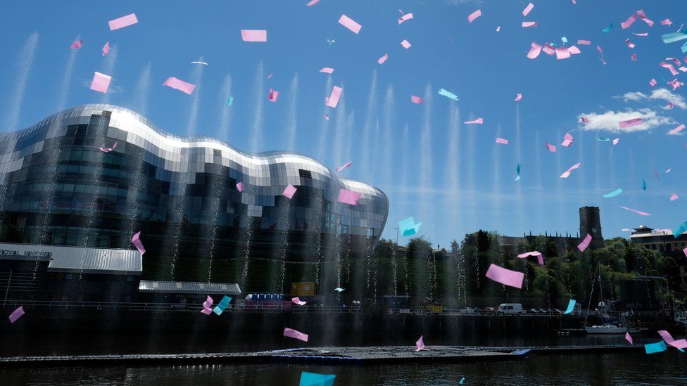 Confetti and a water fountain art installation displays in the middle of the River Tyne
