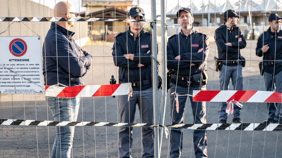 Police on guard at gate to the port in Catania