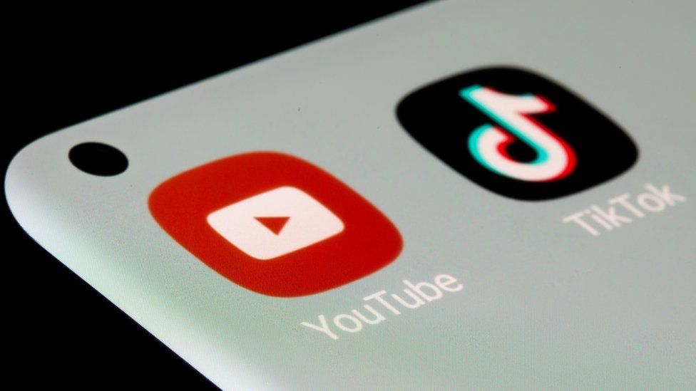 Логотипы YouTube и TikTok на экране смартфона