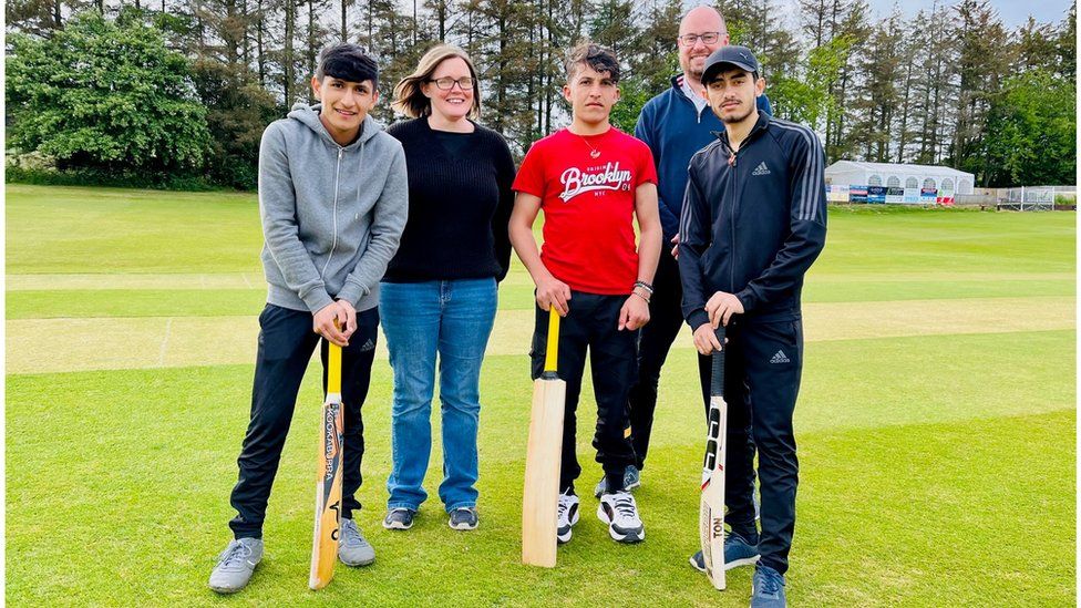 Romal, Sadam and Shokib with support worker Amy and cricket official Kenny Paterson