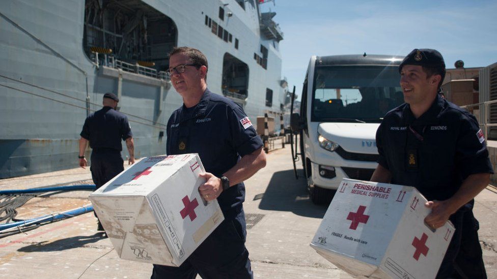 Members of the British Navy carry medical supplies