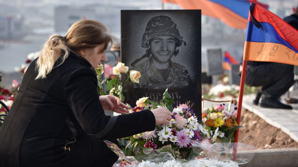A woman visits the grave of a soldier killed during the Nagorno-Karabakh conflict of 2020.