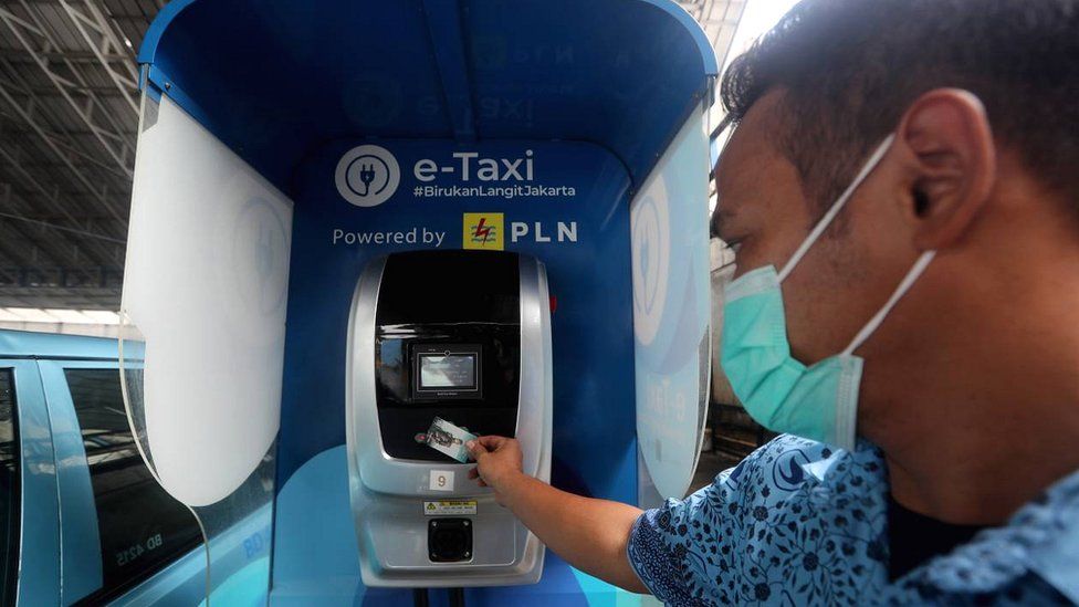 Jakarta taxi driver charging up car