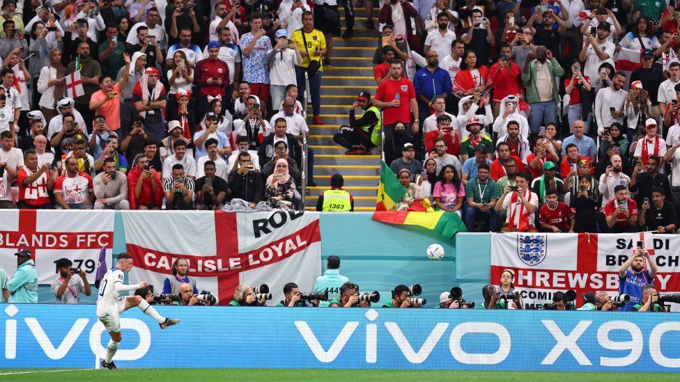 Phil Foden in front of English flags in Qatar