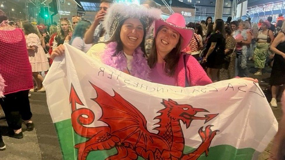 Sisters Emily and Katie Moon in the crowd holding a Welsh flag