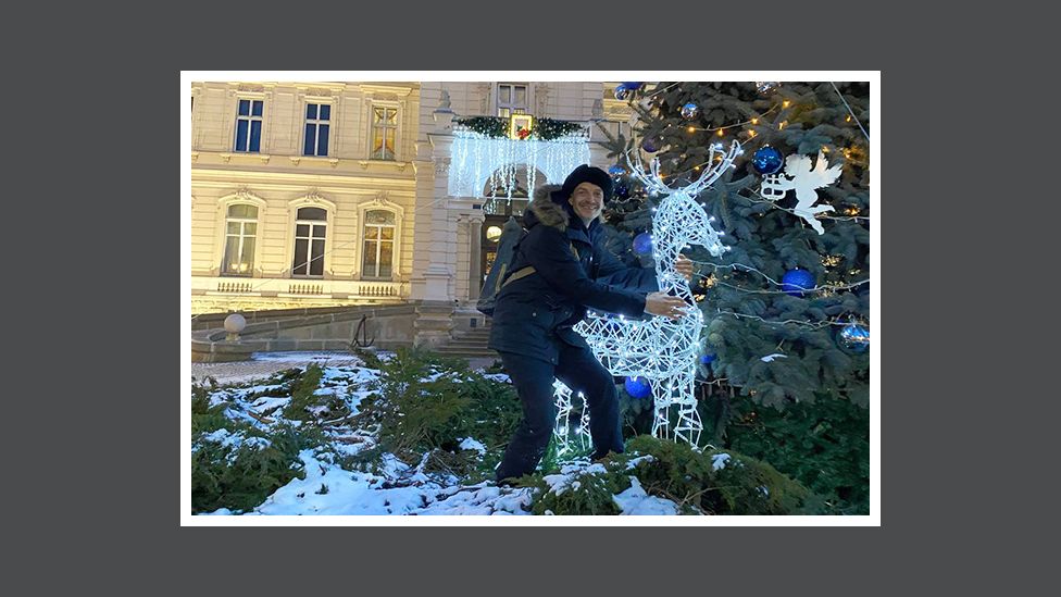 Andriy umarmt eine Rentierdekoration vor der Nationalen Kunstgalerie in Lviv