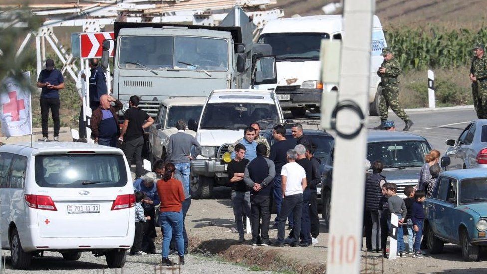 People, including Armenian service members and refugees from Nagorno-Karabakh region, gather at a checkpoint in the village of Kornidzor, Armenia, 24 September 2023.