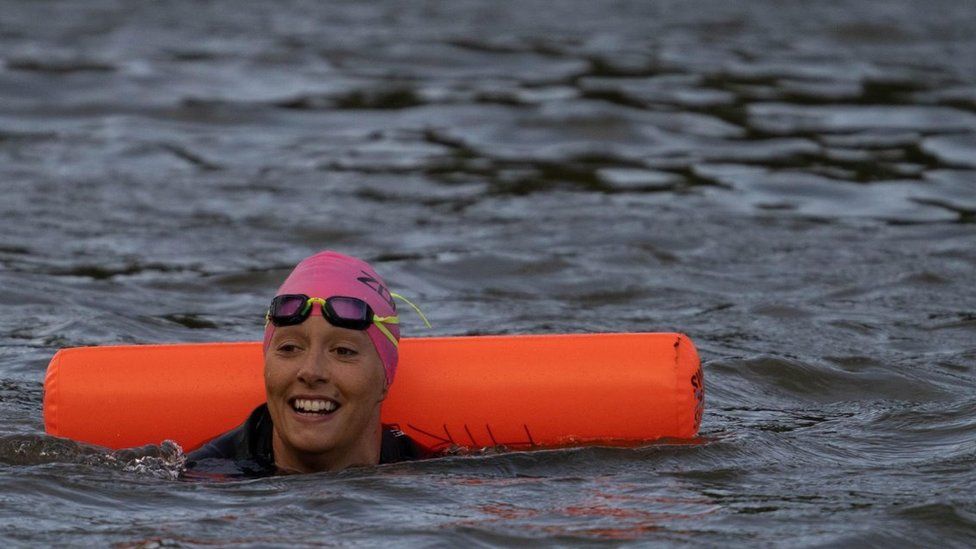 A swimmer with a brightly coloured tow float