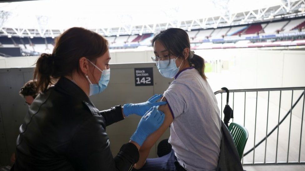 A woman receives a Covid vaccine at the London Stadium on 19 June 2021