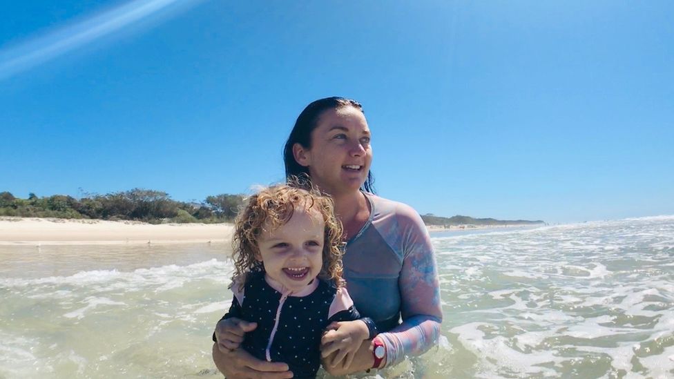 Katie Stoddart and her young daughter in the waves