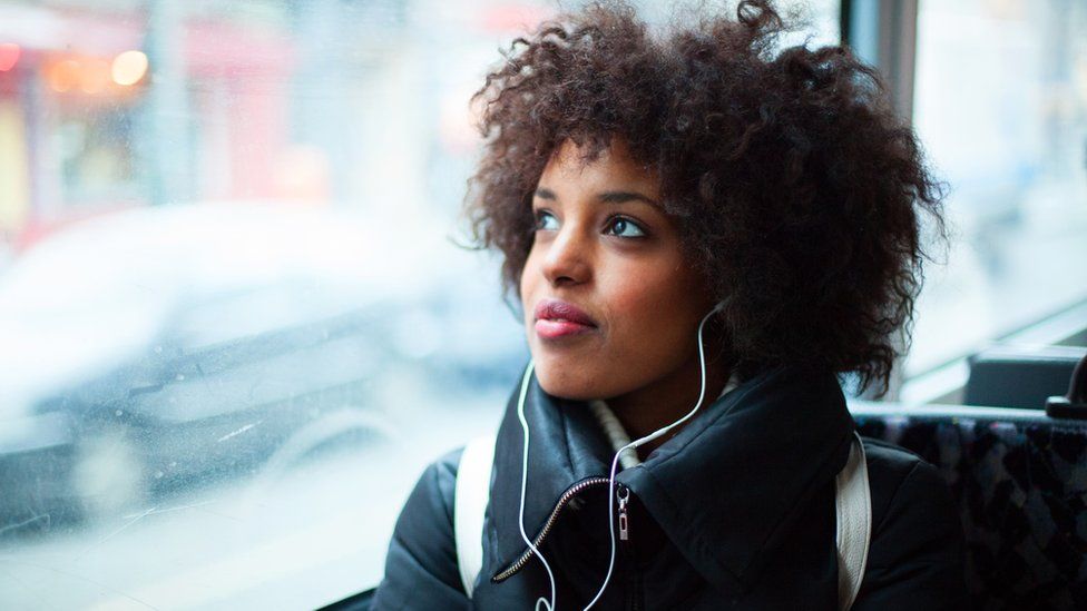 woman listening to headphones on train