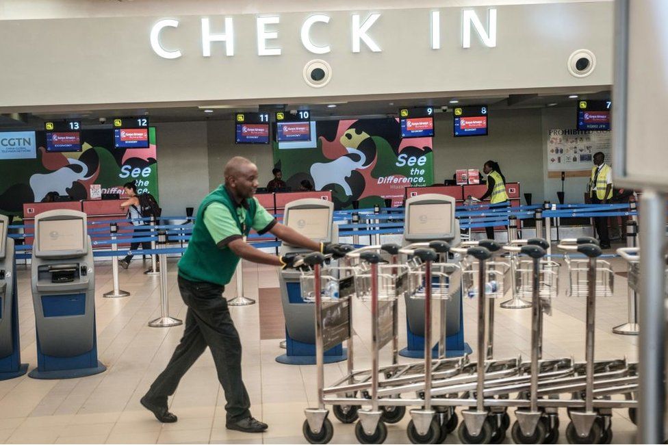 A man moves luggage carts inside the Jomo Kenyatta International Airport in Nairobi, Kenya.