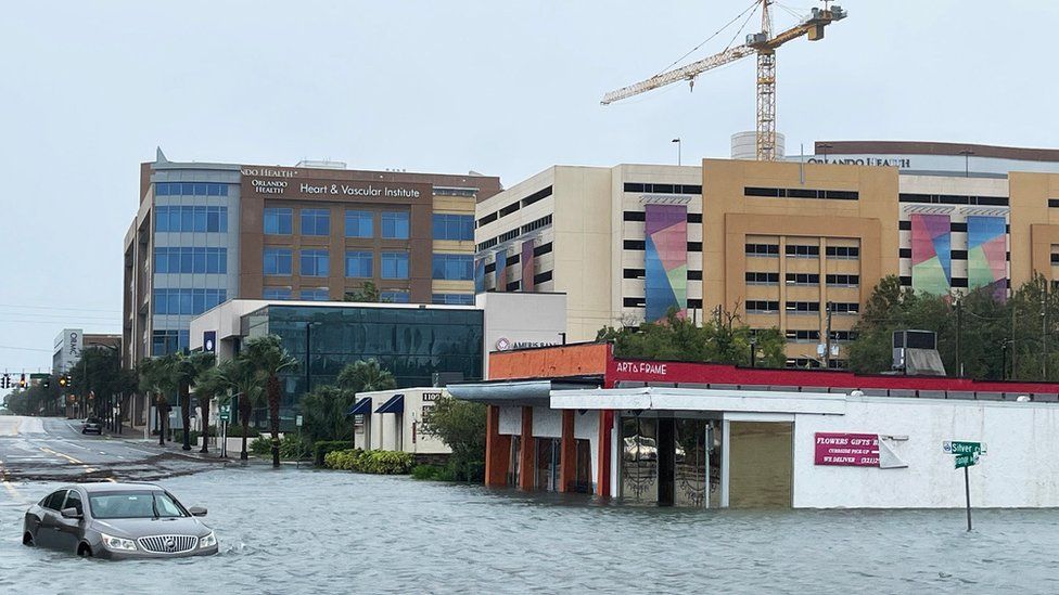 A vehicle sits partially submerged in a flooded downtown following Hurricane Ian, in Orlando