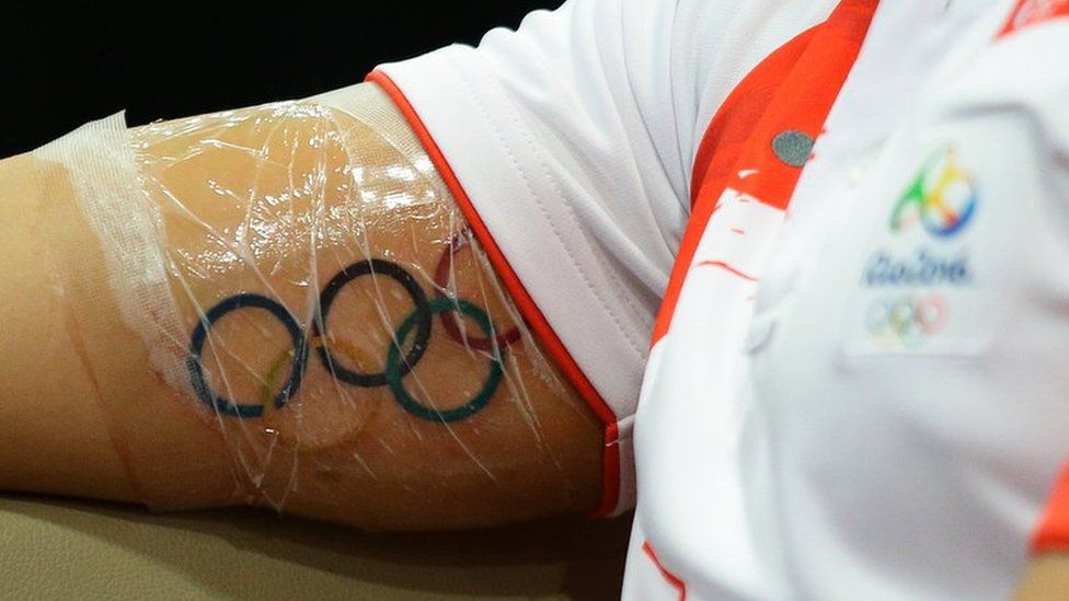 The Olympic Rings tattoo is seen on Singaporean Swimmer Joseph Schooling arm as he speaks to the media during a press conference at the OCBC Aquatic Centre on August 16, 2016 in Singapore