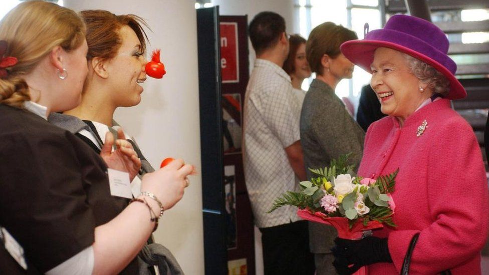 The Queen meeting two students both wearing red noses for Comic Relief Day at North Hertfordshire College in Stevenage
