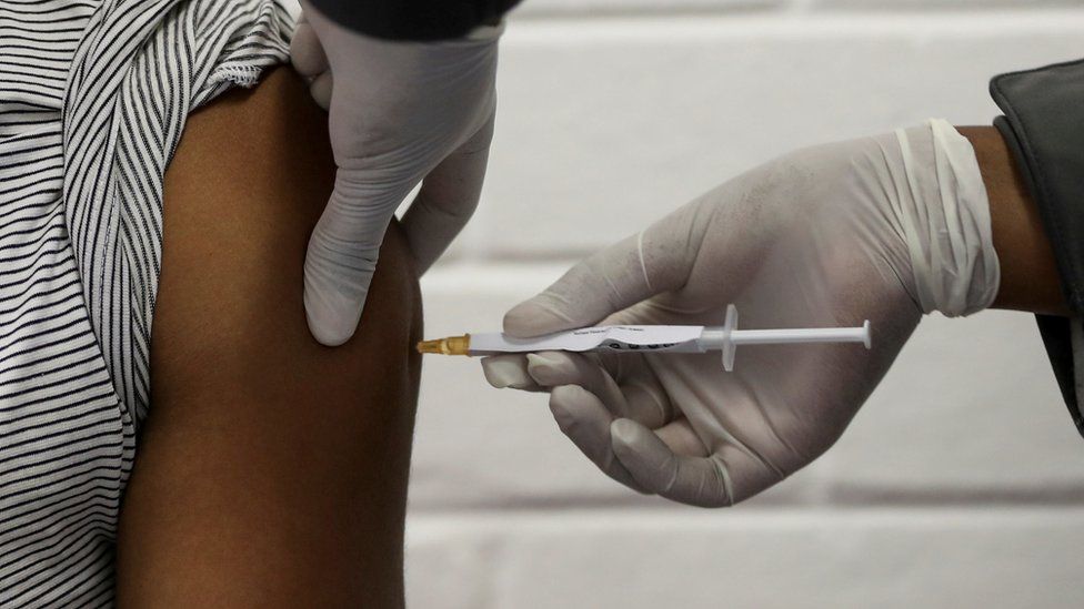 Un volontaire reçoit une injection d'un travailleur médical lors du premier essai clinique humain du pays pour un vaccin potentiel contre le nouveau coronavirus, à l'hôpital Baragwanath de Soweto, Afrique du Sud, le 24 juin 2020.