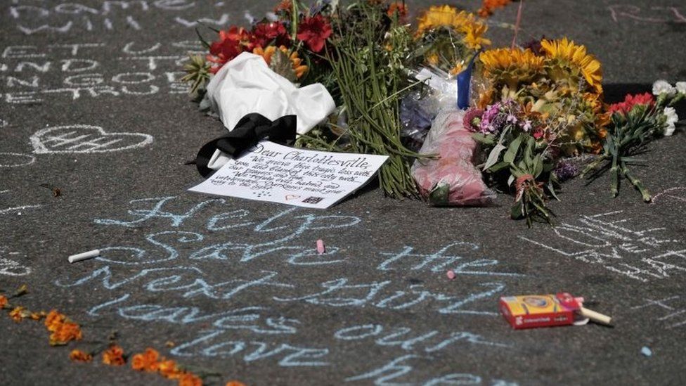Flowers lie at a makeshift memorial a day after a car hit counter-protesters in Charlottesville, Virginia, 13 August 2017.