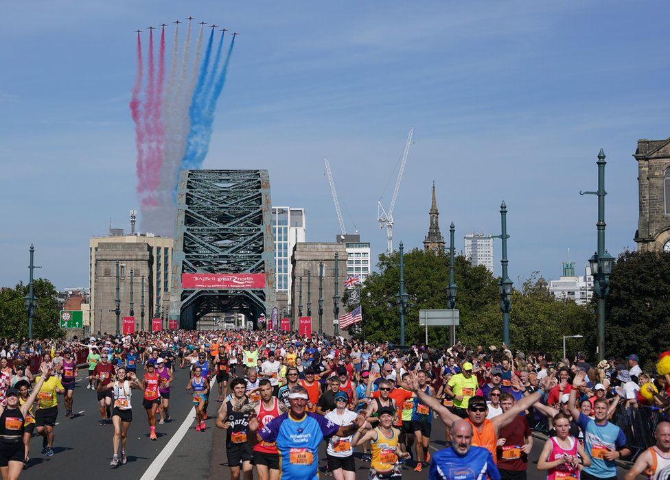 The Red Arrows Royal Air Force aerobatic display perform a flypast as runners cross the Tyne bridge during the AJ Bell Great North Run