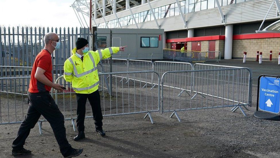 Man walks into Riverside Stadium which is a vaccine centre