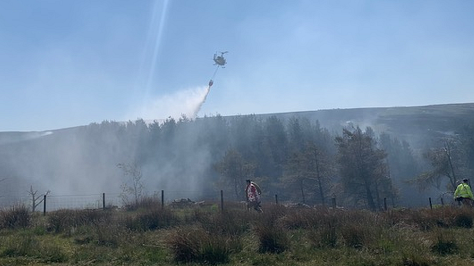 A United Utilities helicopter is helping crews tackle the fire
