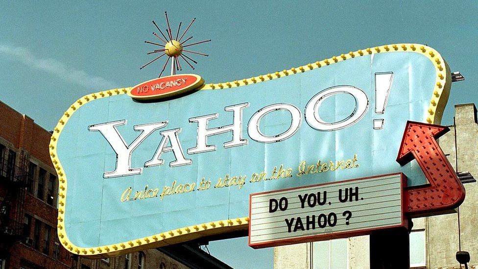 A sign for the Yahoo! Internet search engine rises above lower Manhattan in this February 10, 2000