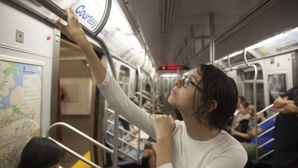 Woman looking up at subway ads