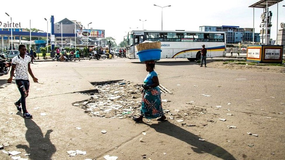 People walk in an empty street in Kinshasa on April 3, 2017 during a general strike called by the opposition
