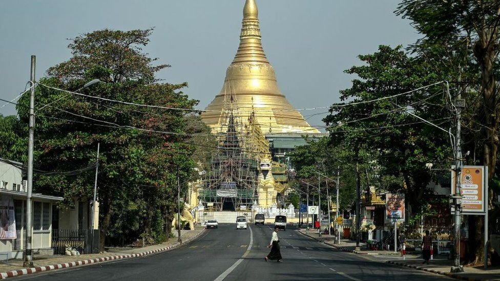 A man crosses an almost empty street near Shwe Dagon Pagoda during a "silent strike" in Myanmar