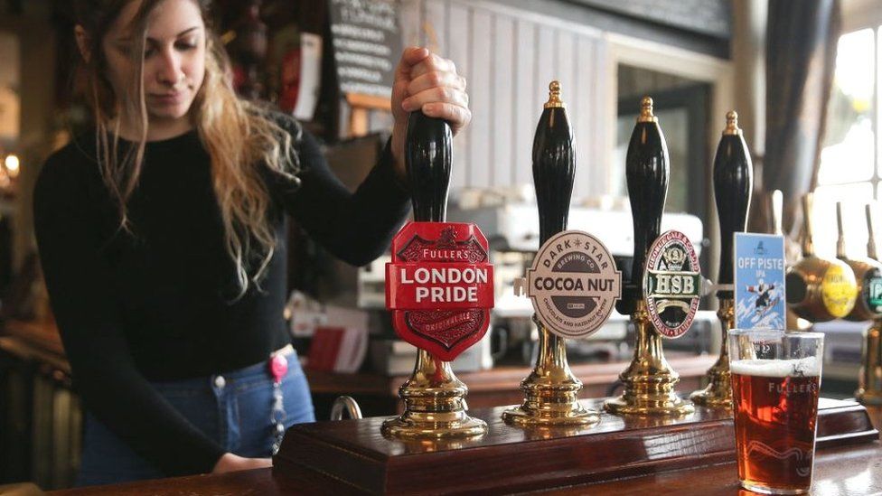 Bartender pulling a pint in a Fuller's pub