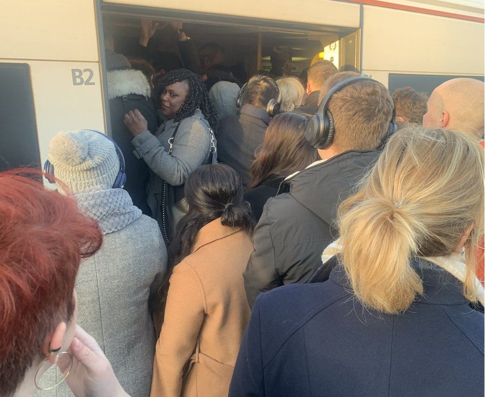 Commuters trying to get on to a train